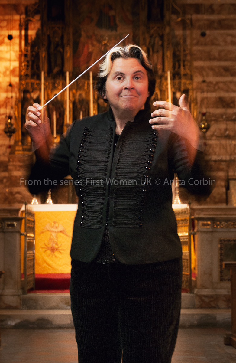 A woman conducting, dressed in black.